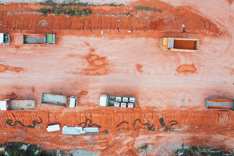 Aerial View Of Trucks On An Orange Soil Terrain