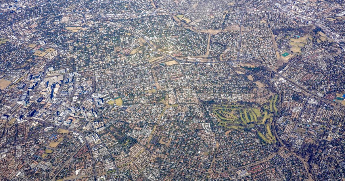 Luftbild einer dichten Stadtlandschaft mit Straßen und Grünflächen als neues Einzugsgebiet für eine expandierende Reinigungsfirma