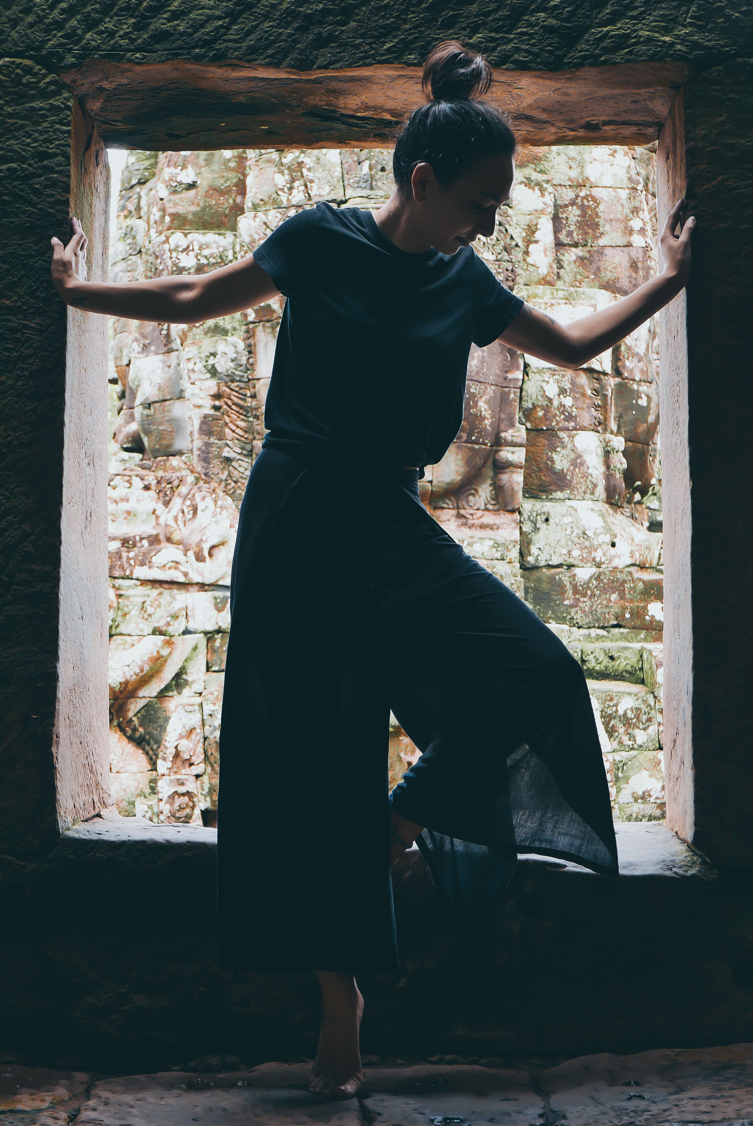 A Woman Standing Beside the Concrete Window · Free Stock Photo