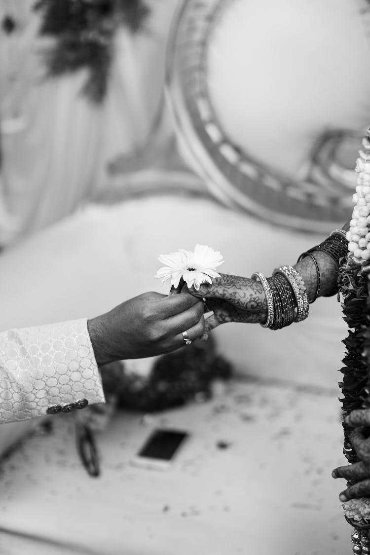 Indian Bride And Groom Holding A Flower Together