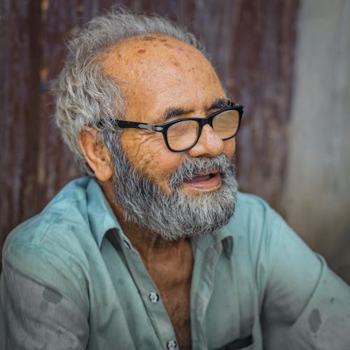 A Man in Green Button Up Shirt Wearing Black Framed Eyeglasses