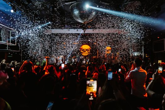 Dynamic concert scene in Mantova with confetti, crowd, and striking light show.