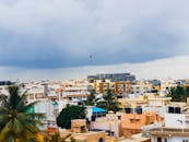 从空中俯瞰班加罗尔的城市景观，天空多云，建筑物林立