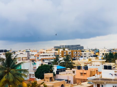 Aerial view of Bengaluru's urban landscape with cloudy sky and buildings.