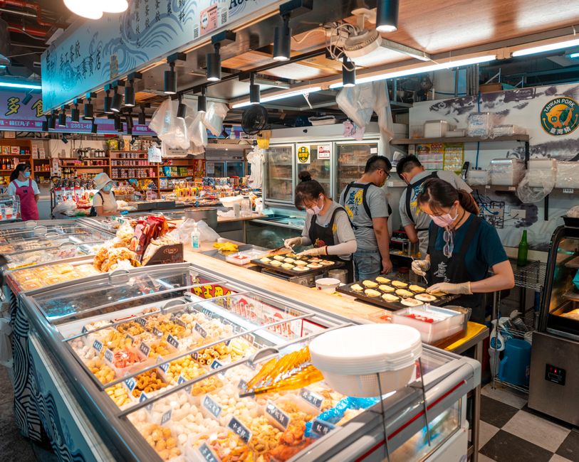 Busy Asian market scene with shoppers and food displays, showcasing a vibrant indoor setting. Busy Asian market scene with shoppers and food displays, showcasing a vibrant indoor setting.