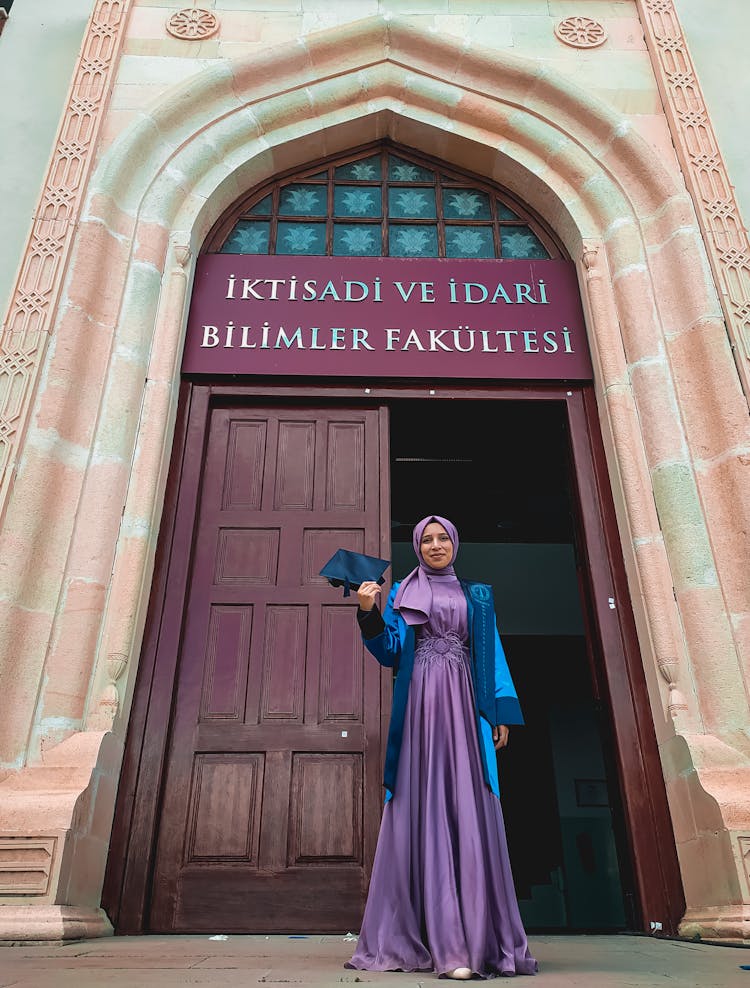 A Woman Standing In Front Of A University