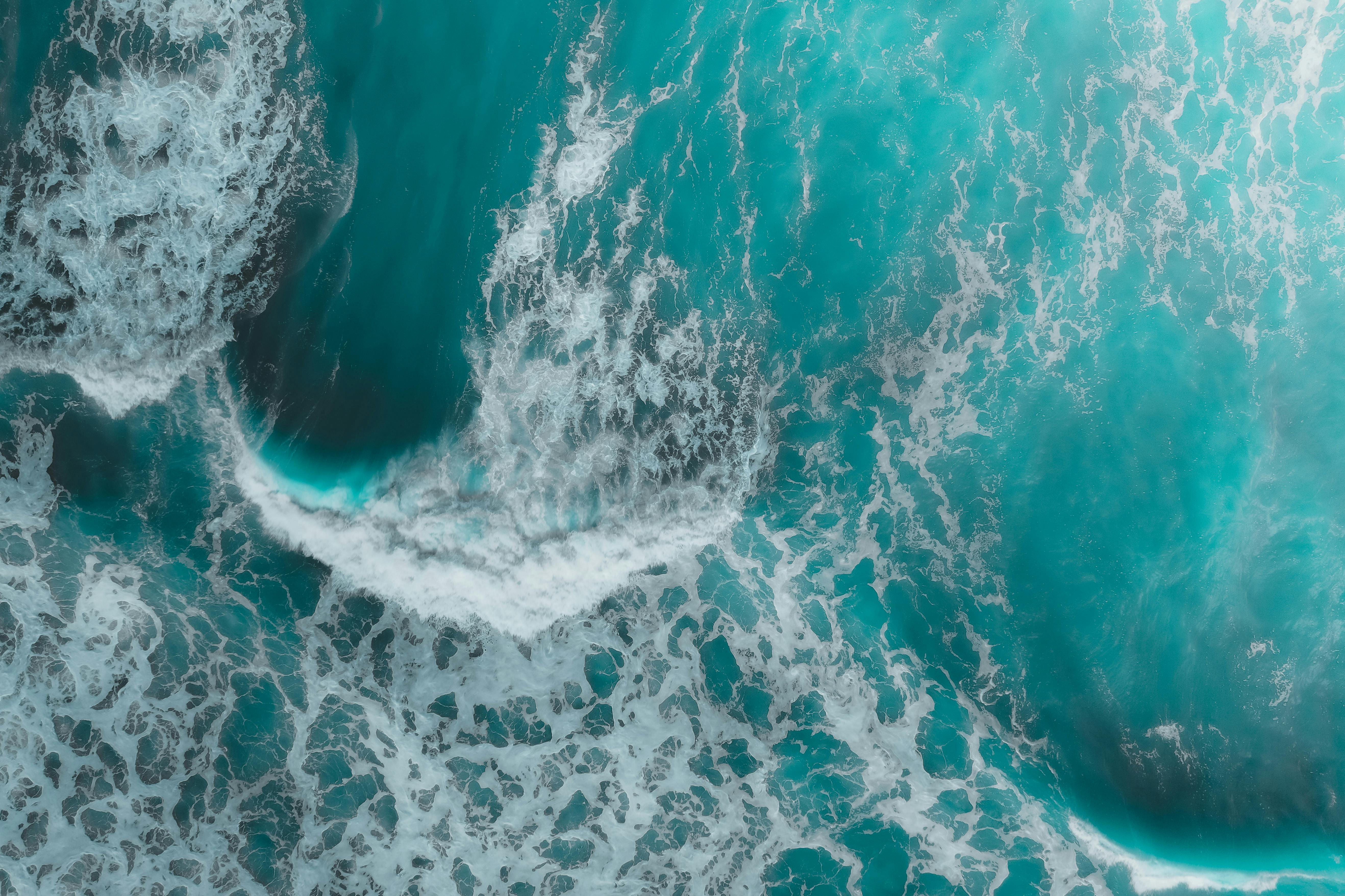 A stunning aerial view of turquoise ocean waves crashing, creating a mesmerizing texture.