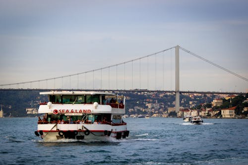 Ferry Boat Cruising on Sea Near Bridge