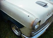 这张复古汽车引擎盖的特写，展现了铁锈与经典特征，非常适合古董爱好者