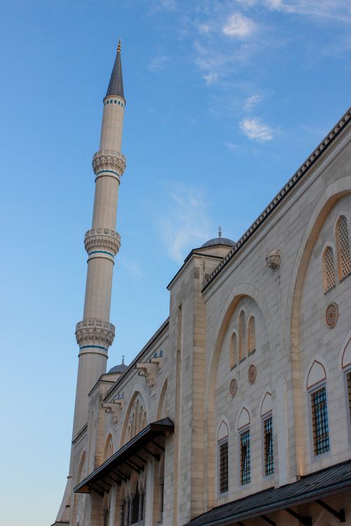 Free Stunning low angle view of a mosque minaret with blue sky and clouds. Captures religious architecture. Stock Photo