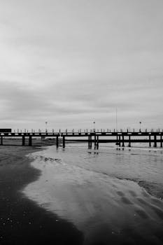 Dramatic black and white photo of a pier stretching over the sea in Mar del Plata, Argentina.