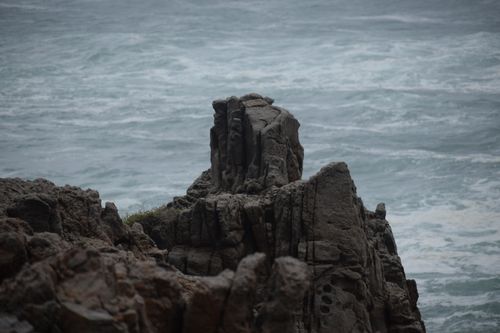 Free Majestic rocky cliff formation against the powerful ocean waves. Stock Photo