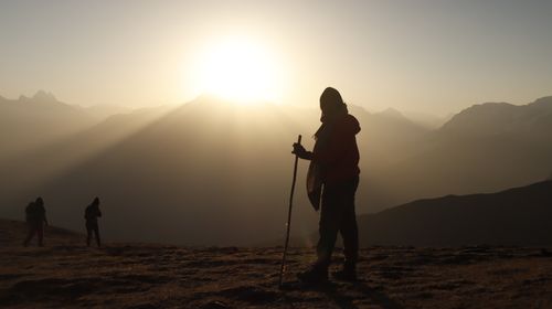 Free Hikers silhouetted against the sunrise in a breathtaking mountain landscape, showcasing nature's beauty. Stock Photo
