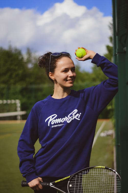 Free Woman in Blue Long Sleeve Shirt Holding Green Tennis Ball Stock Photo