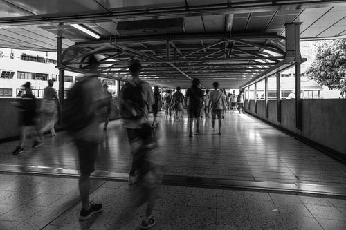 Free Black and white photo of people walking on a footbridge in Hong Kong. Stock Photo