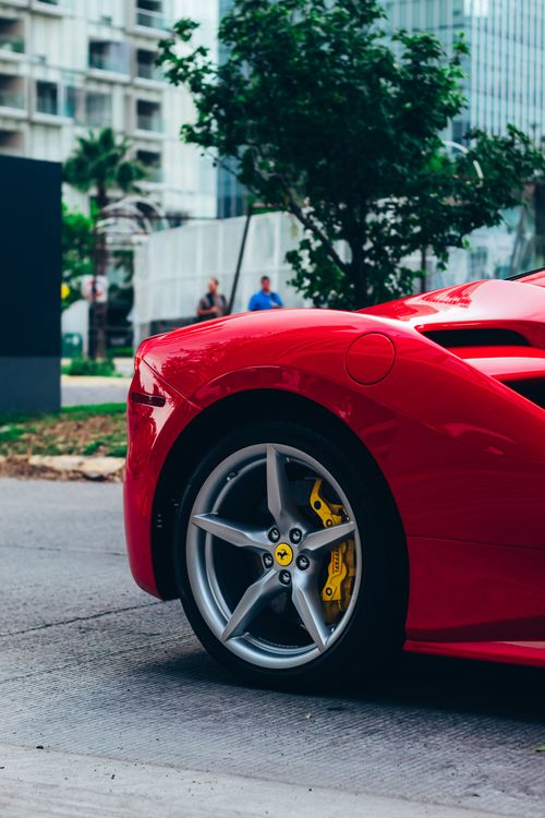 Free Close-up of a parked red Ferrari supercar on a city street. Stock Photo