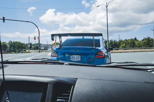 Blue Car Driving on Asphalt Road