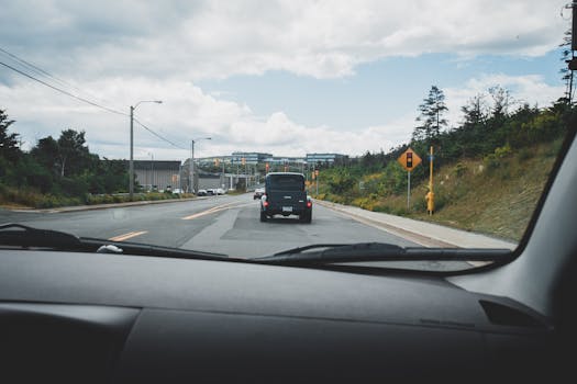 A scenic highway view captured from inside a moving car, showcasing the road ahead and natural surroundings.