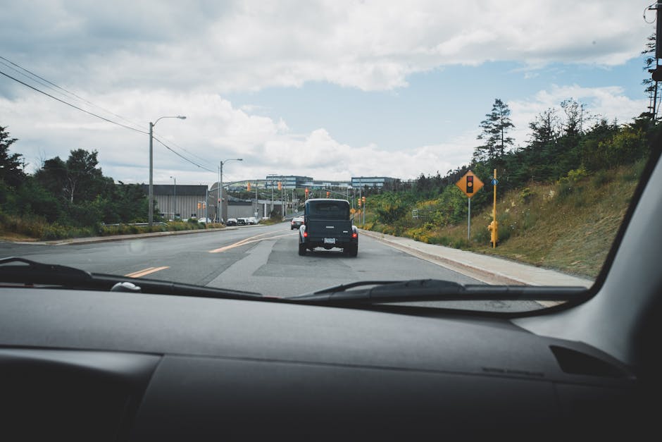 A scenic highway view captured from inside a moving car, showcasing the road ahead and natural surroundings.