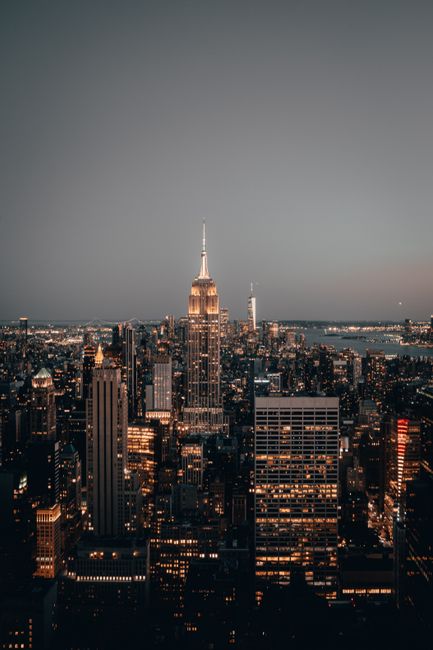 Majestic view of New York City skyline featuring the illuminated Empire State Building at dusk.