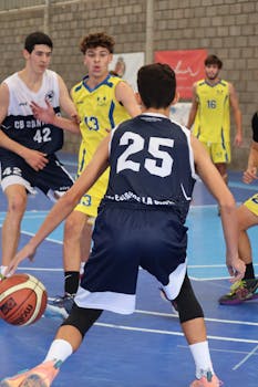 Players engaged in a competitive indoor basketball game showcasing teamwork and sportsmanship.