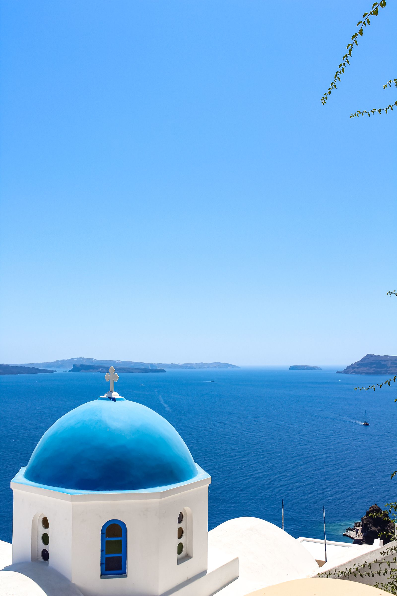 Blue-domed church in Santorini overlooking the Aegean Sea