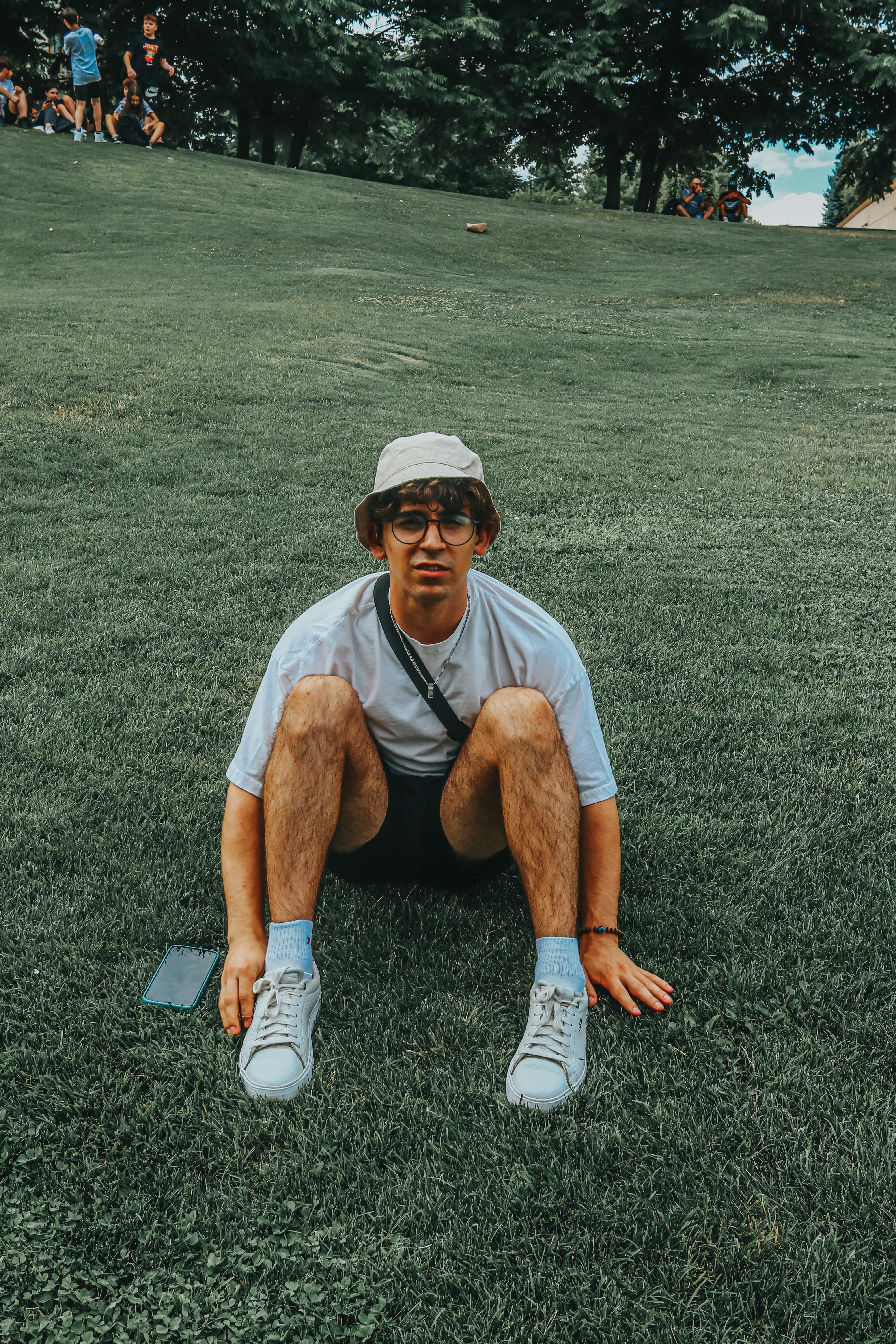 a man sitting on green grass field