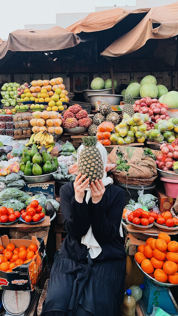 Person Holding Pineapple At Market