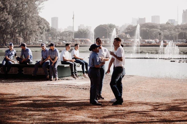 Group Of People Talking In A Park By A Fountain