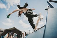 Dynamic shot of a skateboarder executing a trick on a ramp at an urban skate park.