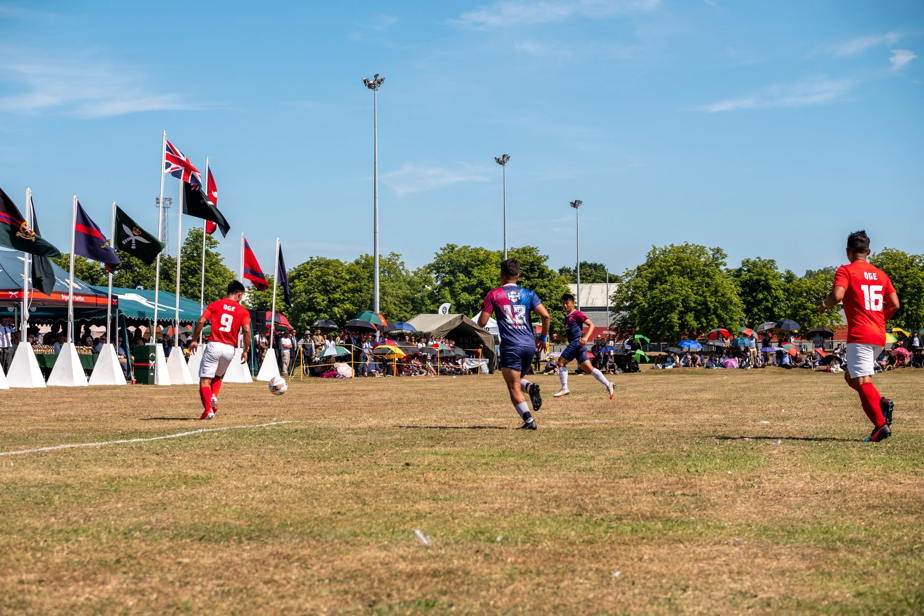 Dynamic action shot of a football match in Aldershot, England with players mid-game.