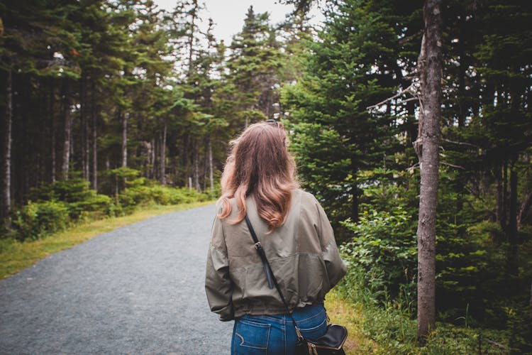 Photo Of A Back View Of The Woman Walking On The Gravel Path In The Forest