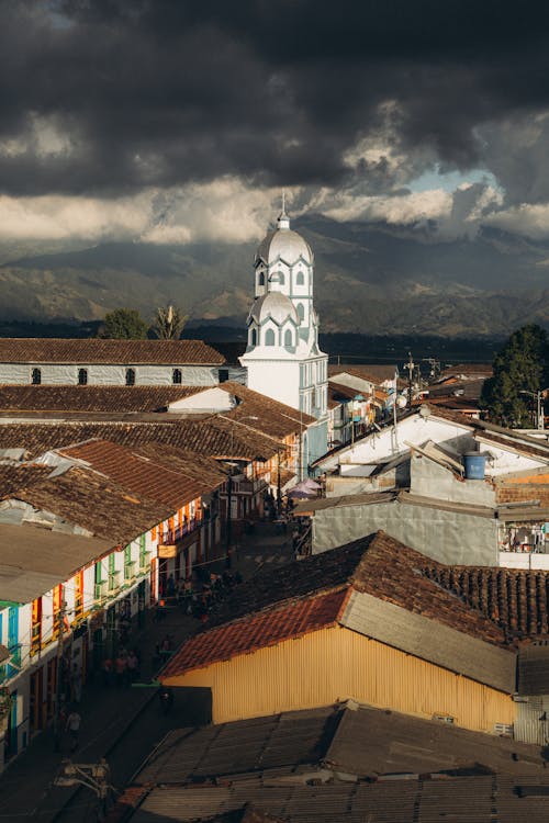 Aerial View of Roofs and Church Building Under Dark Clouds