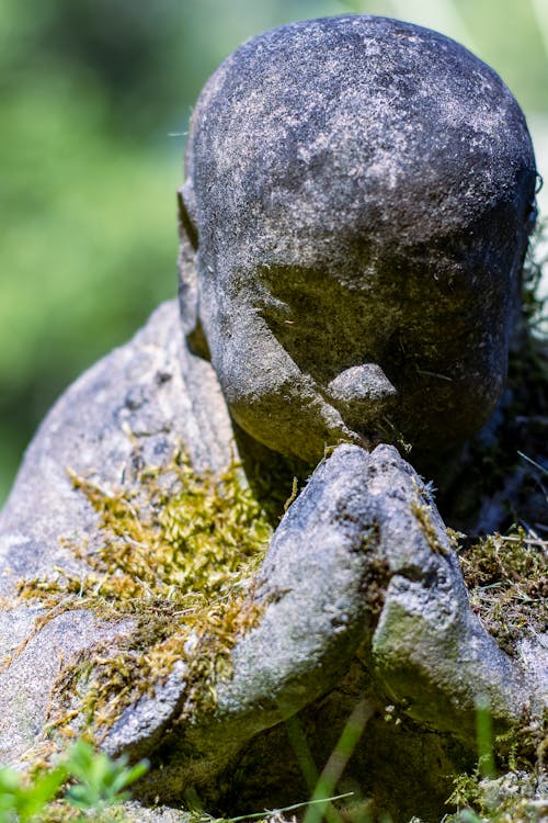 Photo of a Stone Sculpture of Praying Buddha