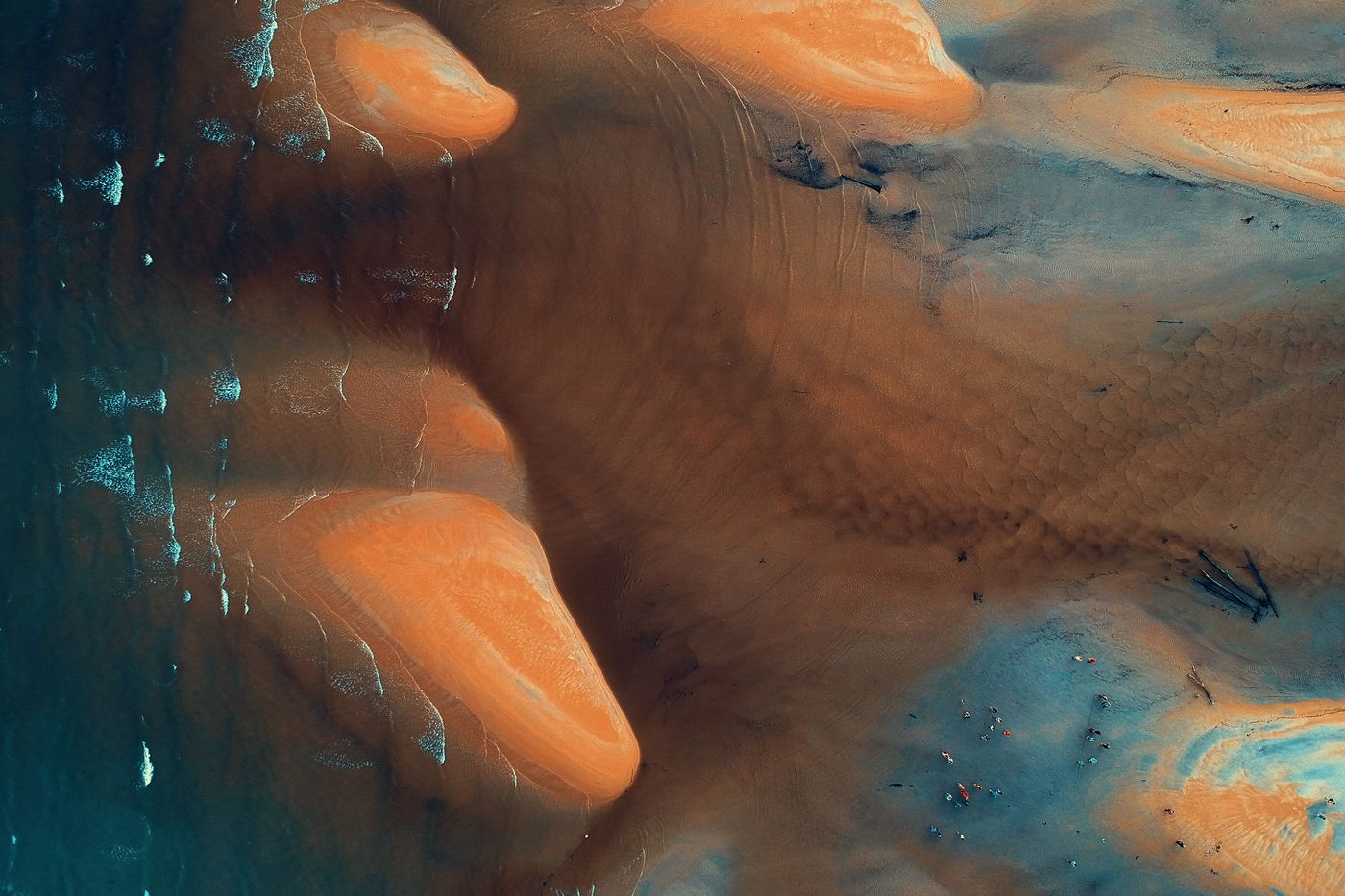 Aerial view of tidal sand formations meeting shallow blue water — photo by Pok Rie on Pexels