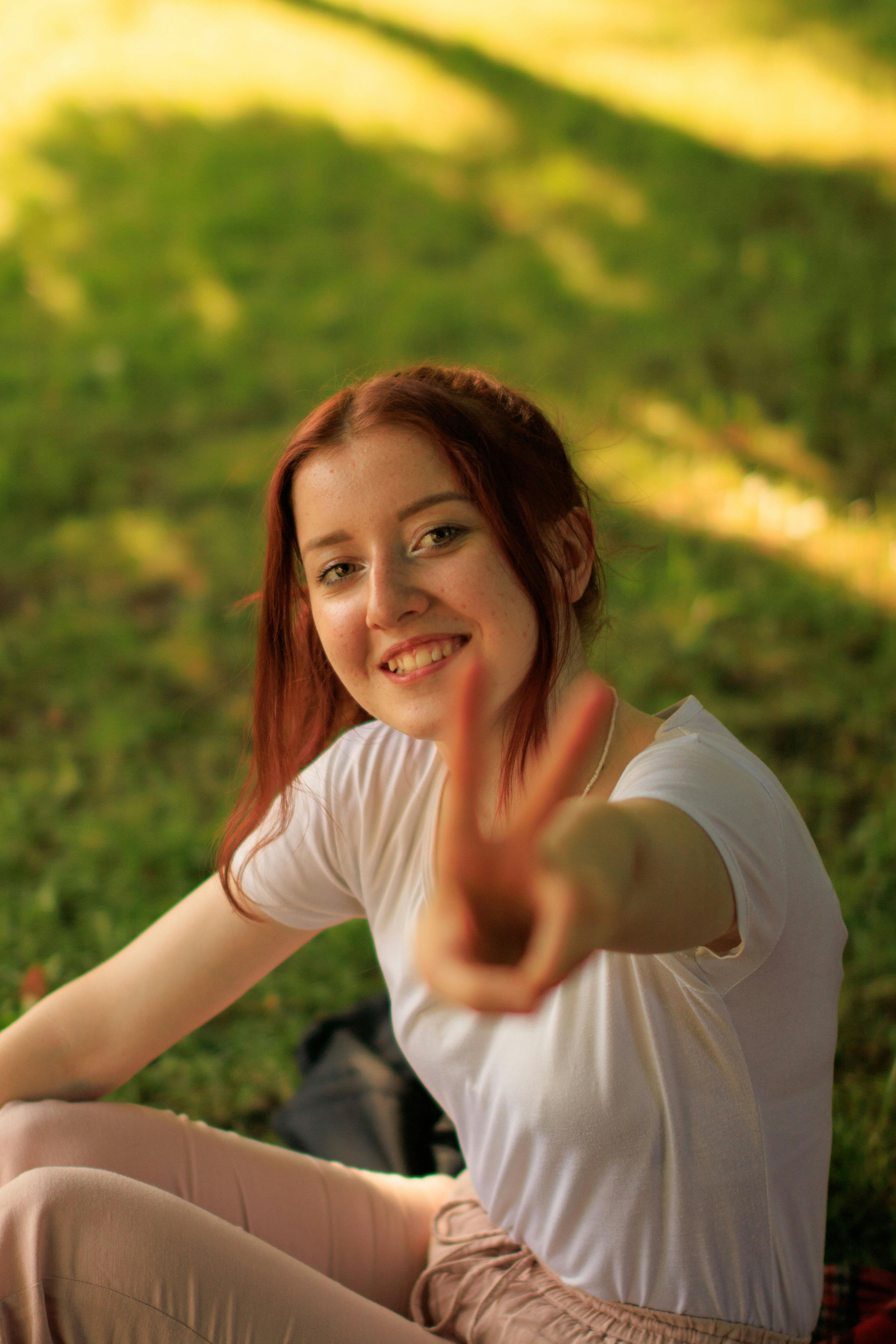 redhead girl showing v sign with fingers