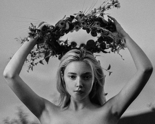 Free Black and white portrait of a woman holding a floral garland over her head. Stock Photo
