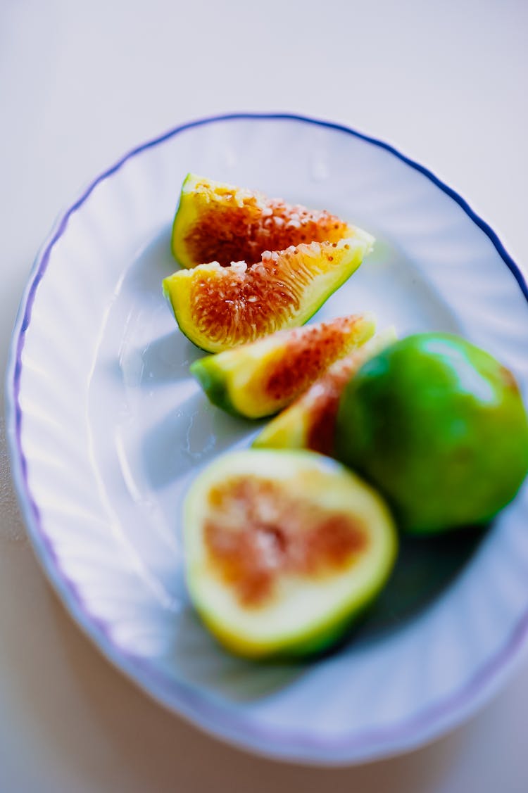 Sliced Green Fruit On White Ceramic Plate