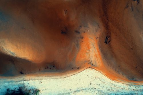 Free Stunning aerial capture showcasing the vibrant colors of a seashore landscape with sandy textures. Stock Photo