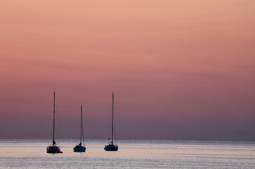 Silhouette of Three Sailing Ships on the Ocean during Sunset