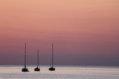 Foto profissional grátis de água, alvorecer, barcos a vela