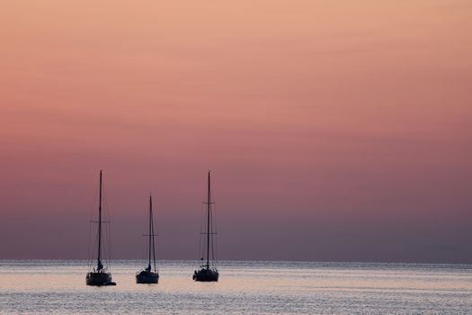 Serene view of sailboats at sunset in Norwalk Bay, capturing peaceful ocean vibes.