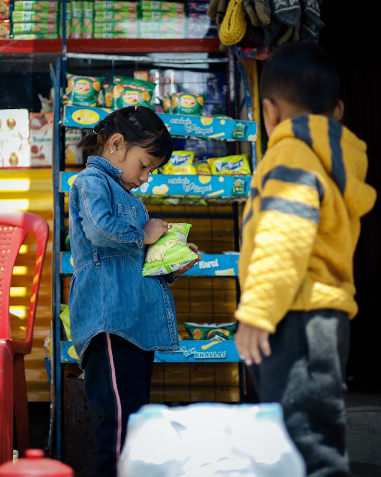 Children Picking Bag Of Chips In Grocery Store