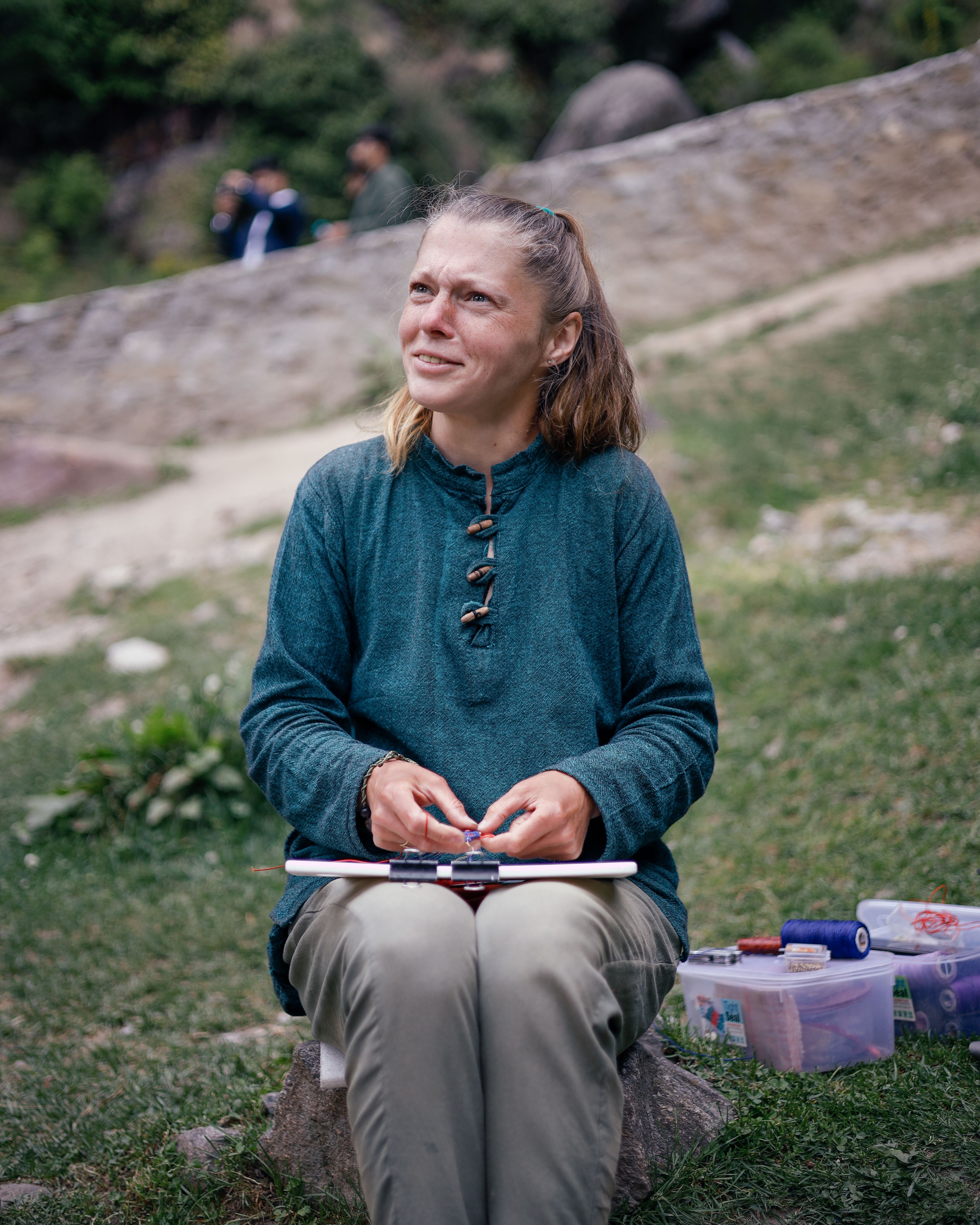 A Woman in Blue Long Sleeve Shirt Sitting on Gray Rock · Free Stock Photo