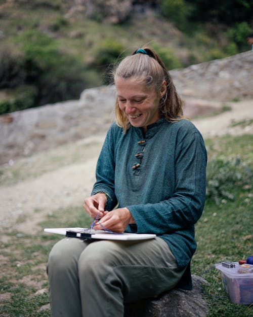Smiling Woman Making a Beaded Accessory