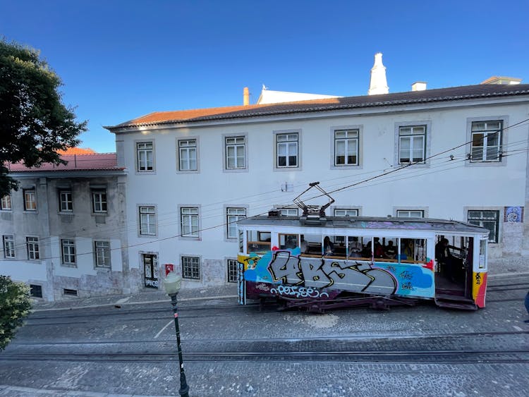 White And Blue Tram On Road Near White Concrete Building