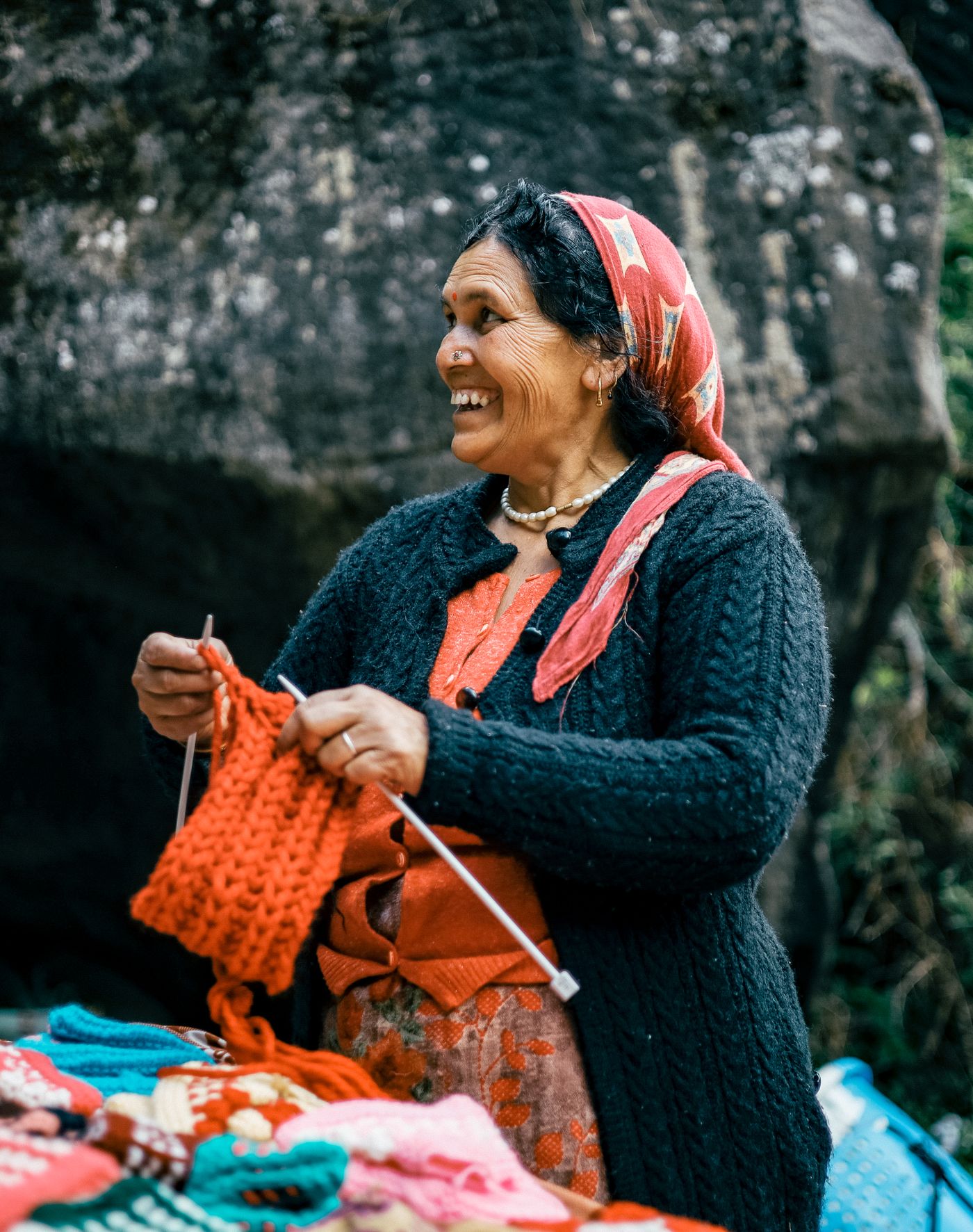 A smiling woman in a traditional Indian market setting, reflecting local skill, service, and community connection.