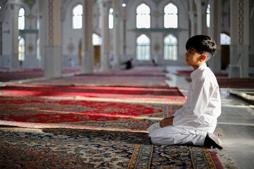 Free Boy Kneeling in Mosque Stock Photo