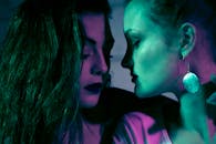 霓虹灯下，两名女性的特写肖像充满戏剧性，着重刻画了她们的情绪与联系