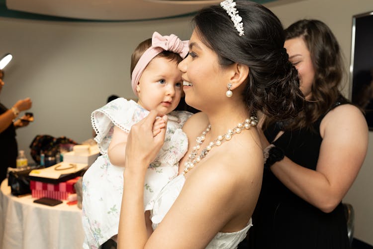 Woman Wearing A Tiara Carrying A Beautiful Girl